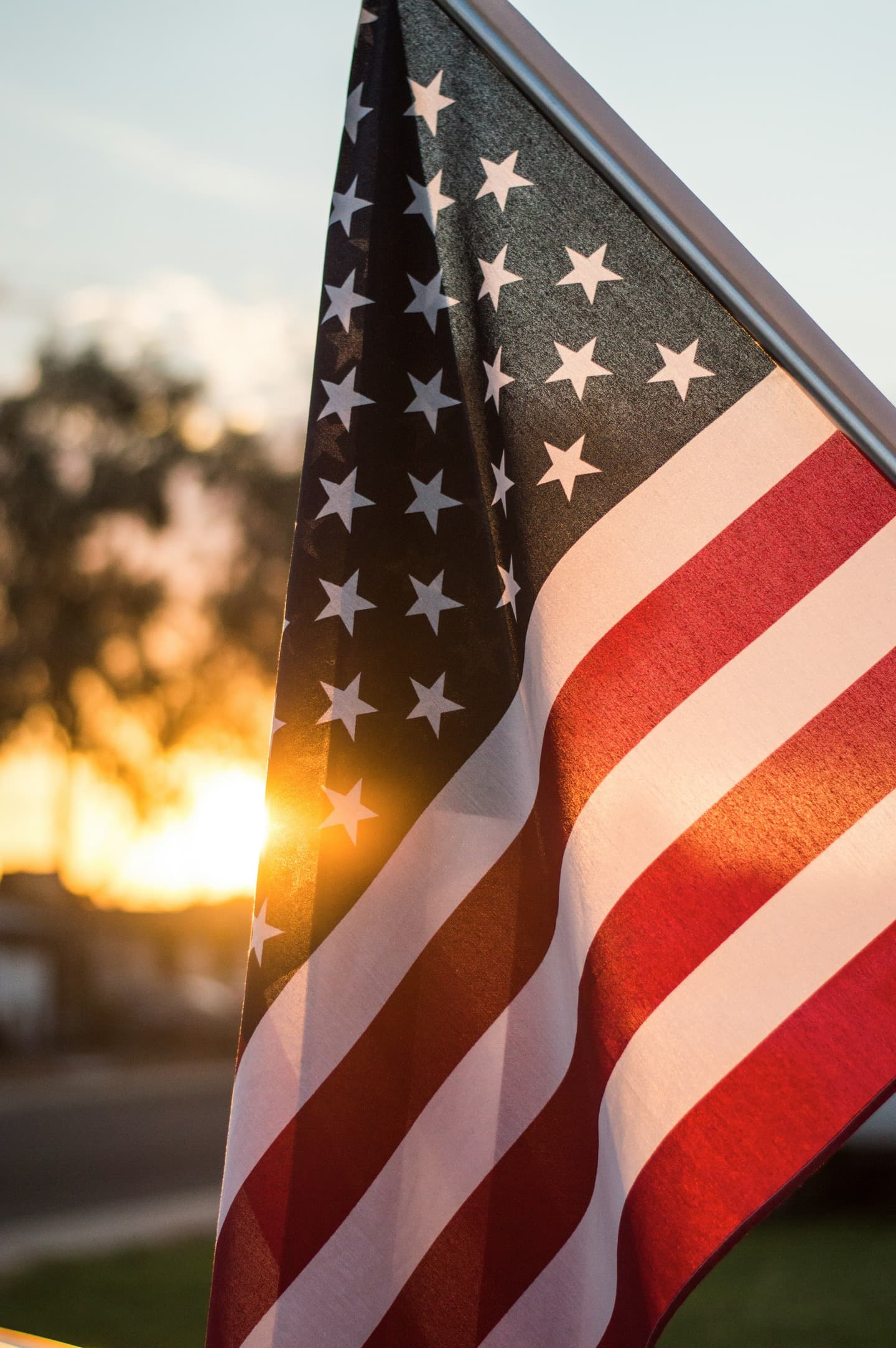 An American flag backlit by the setting sun